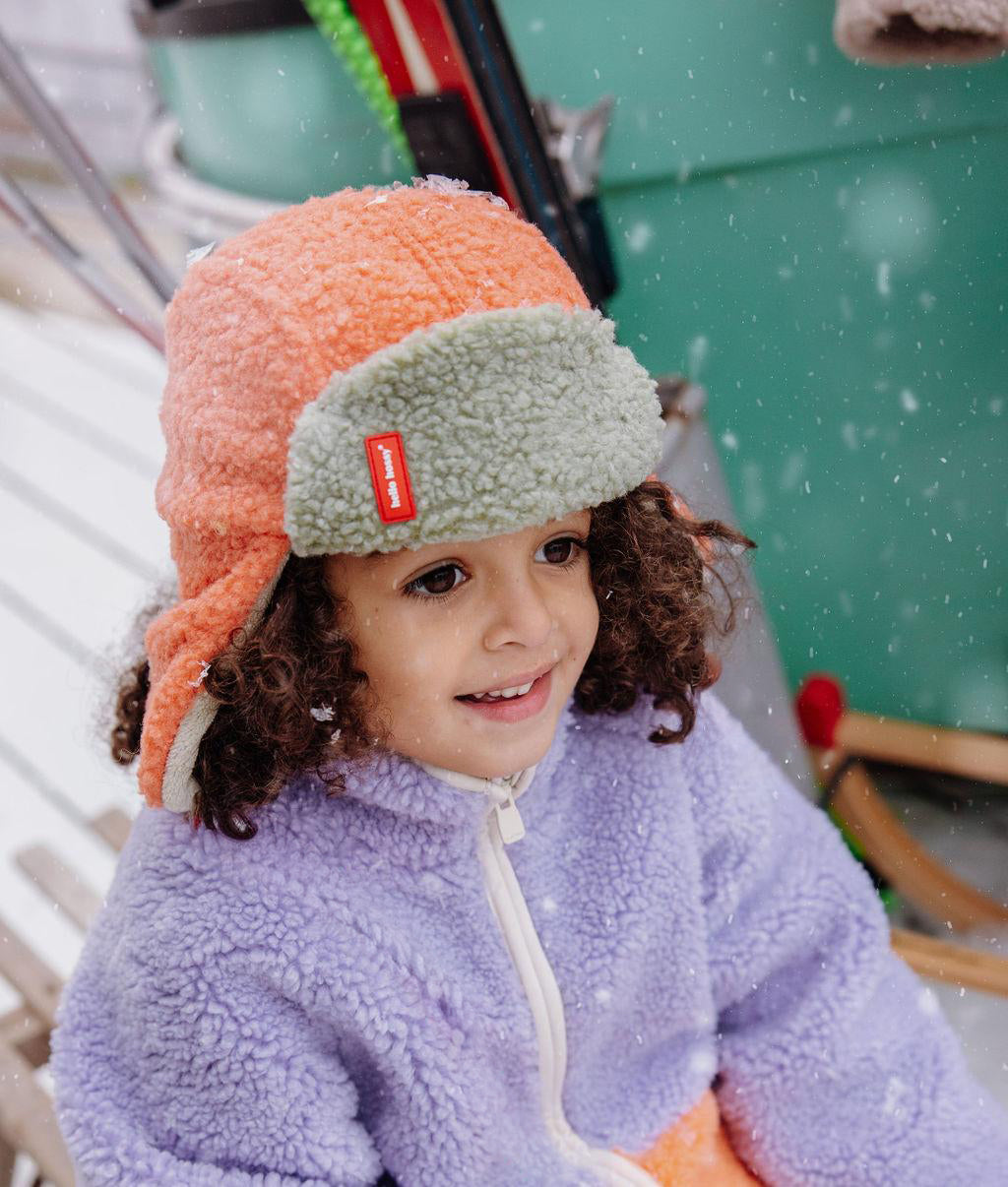 Fille portant la chapka en moumoute bicolore Cozy Jim - vue de 3/4 - Hello Hossy