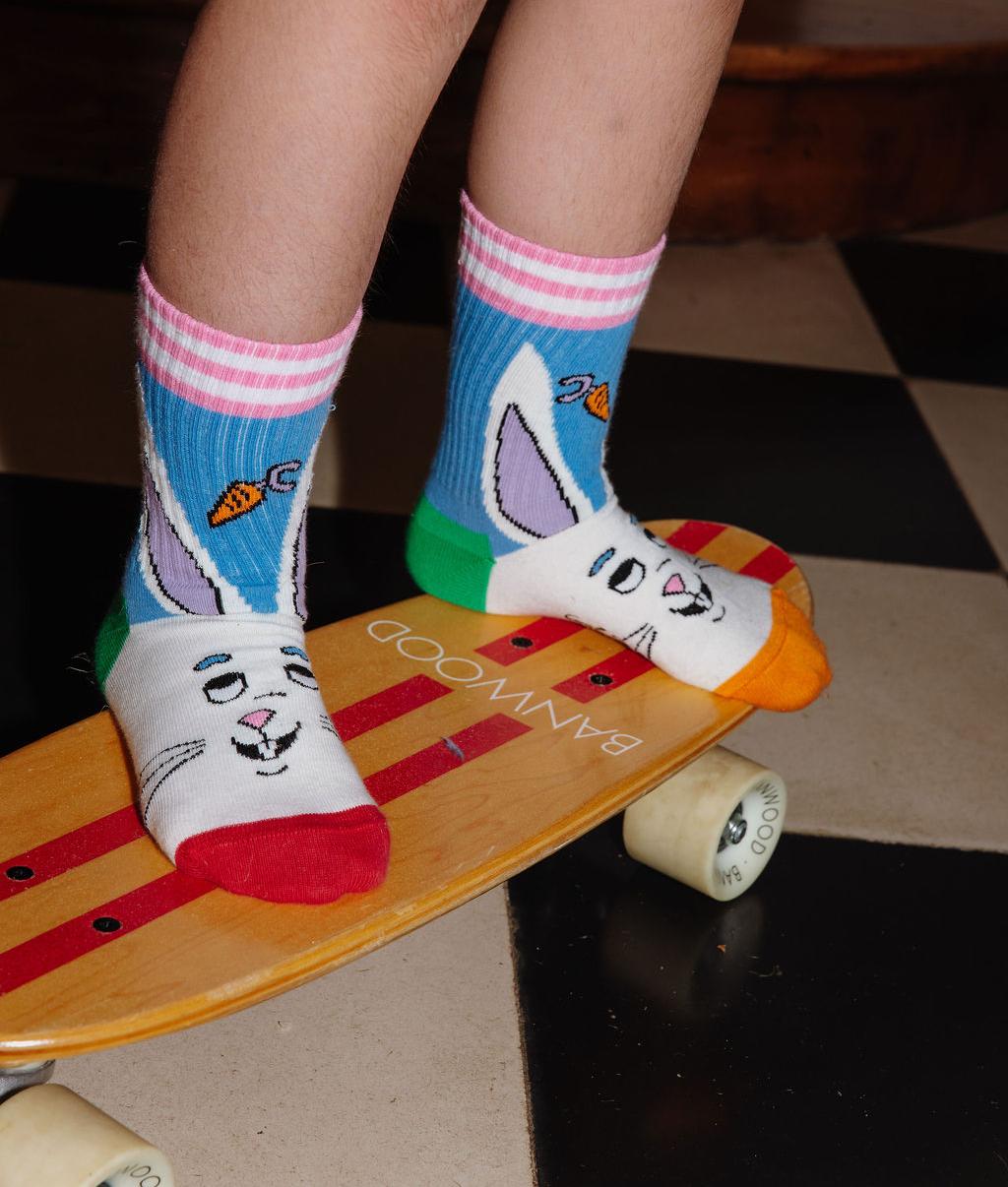 Enfant portant la paire de chaussettes motif mascotte lapin avec haut de tige à rayures - vue de 3/4 - Hello Hossy