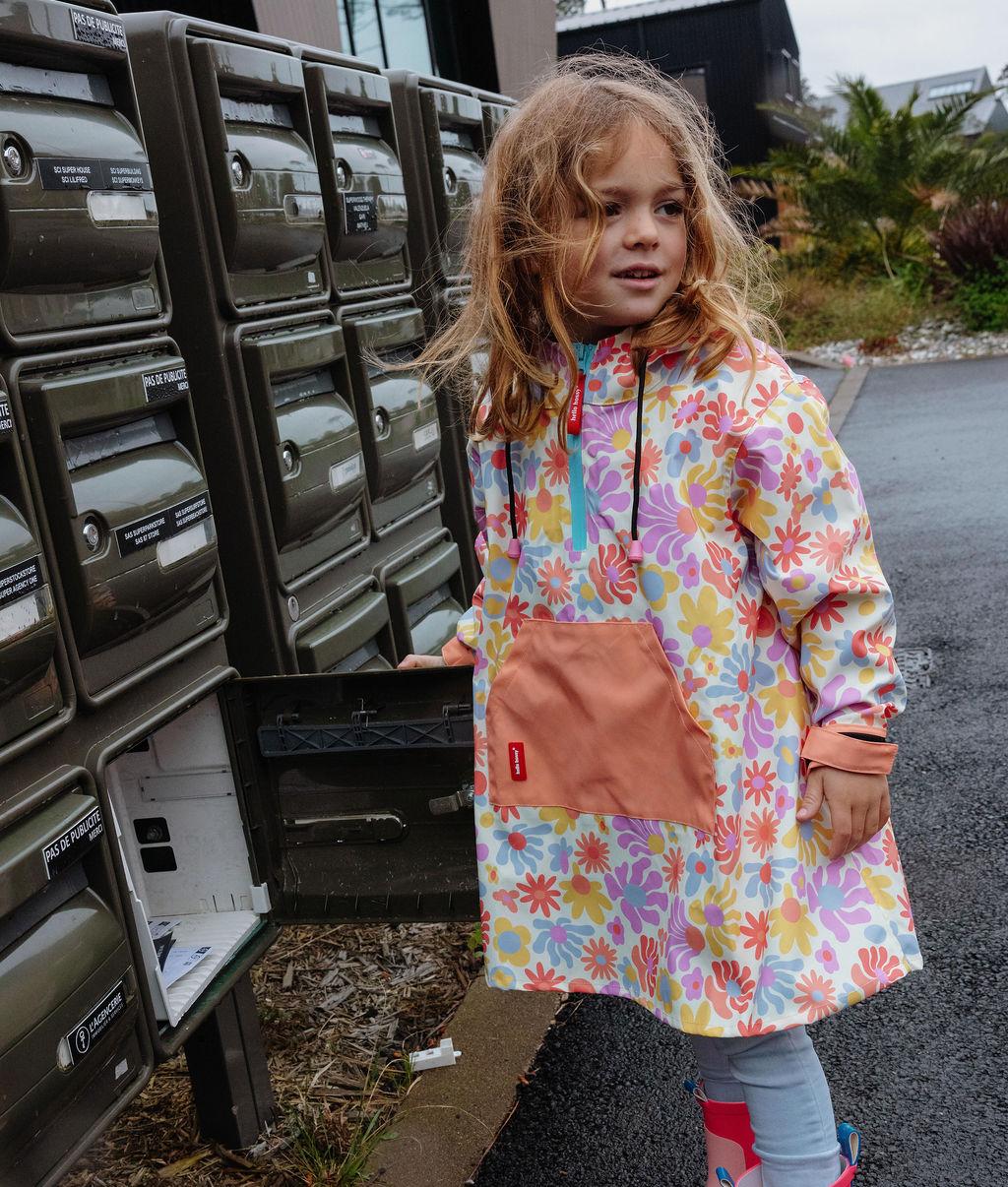 Poncho de pluie imperméable Retro Flowers porté par une fille - vue de 3/4 - photo lifestyle – Hello Hossy