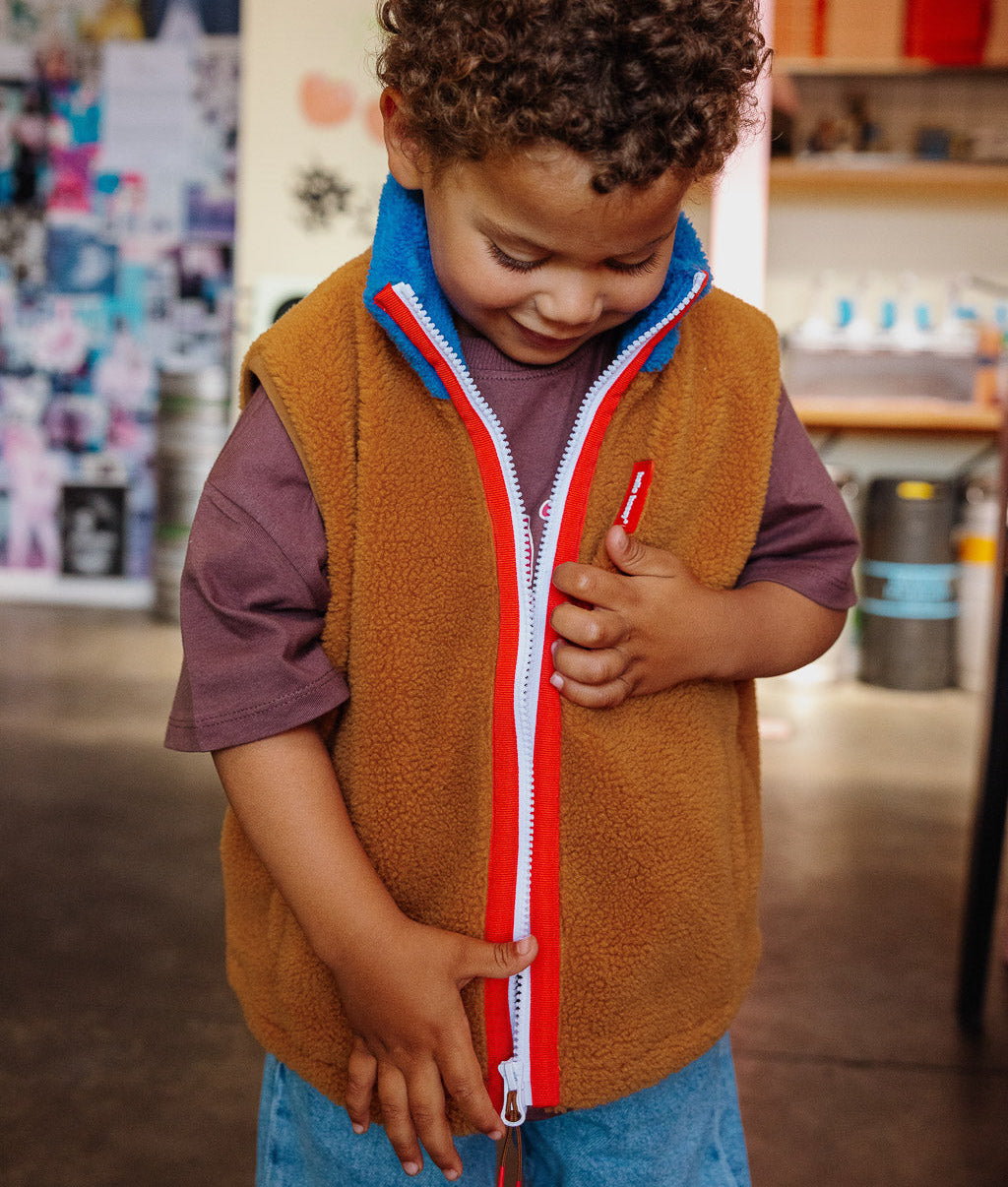 Chaleco polar infantil camel azul con cuello alto y cremallera roja Hello Hossy