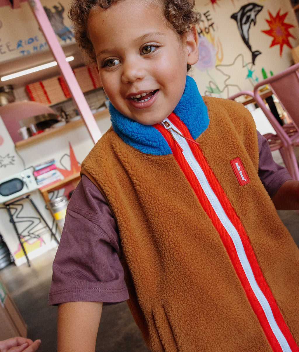 Chaleco polar infantil camel azul con cuello alto y cremallera roja Hello Hossy